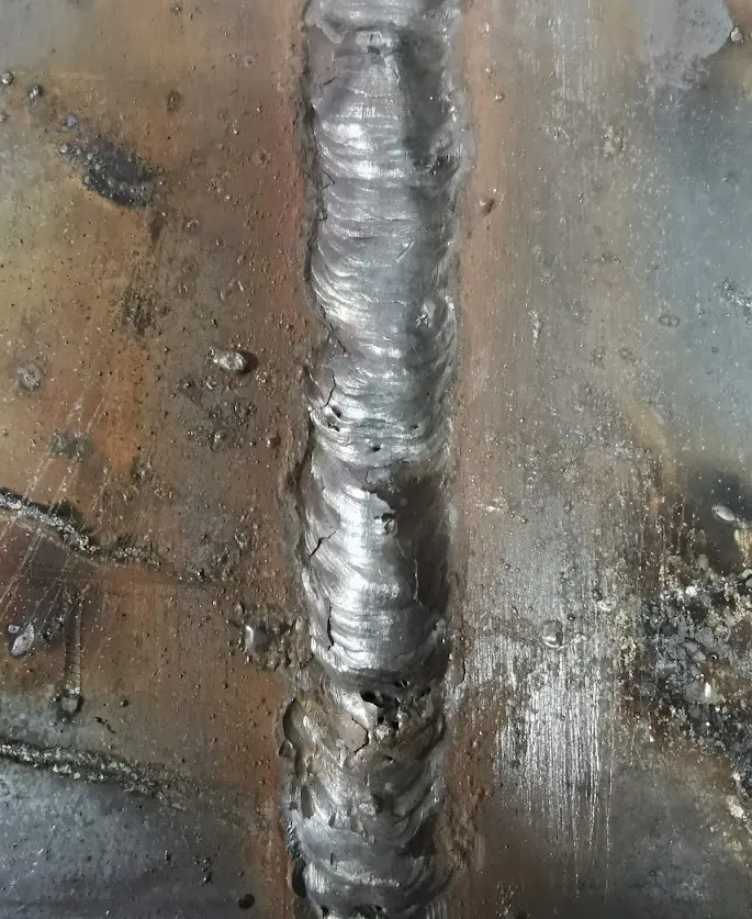 Cordón con escoria atrapada, poros y empalmes irregulares